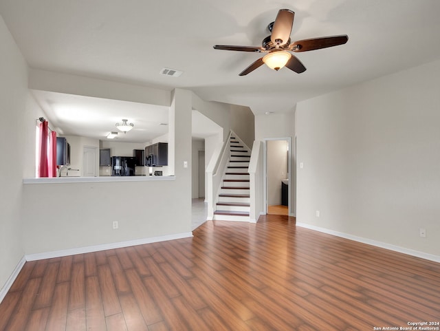 unfurnished living room with ceiling fan and wood-type flooring