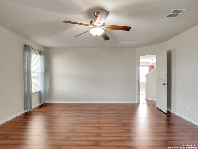 unfurnished room with ceiling fan, dark hardwood / wood-style flooring, and a textured ceiling