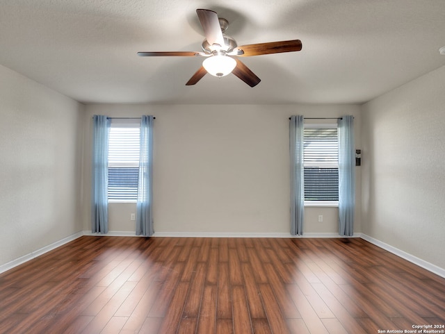 spare room with dark hardwood / wood-style floors, ceiling fan, and a textured ceiling