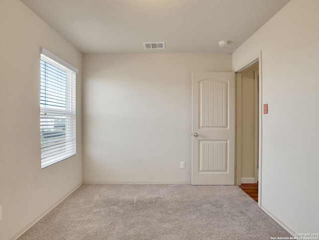 unfurnished room with light carpet