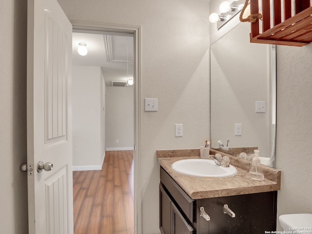 bathroom featuring toilet, vanity, and hardwood / wood-style flooring