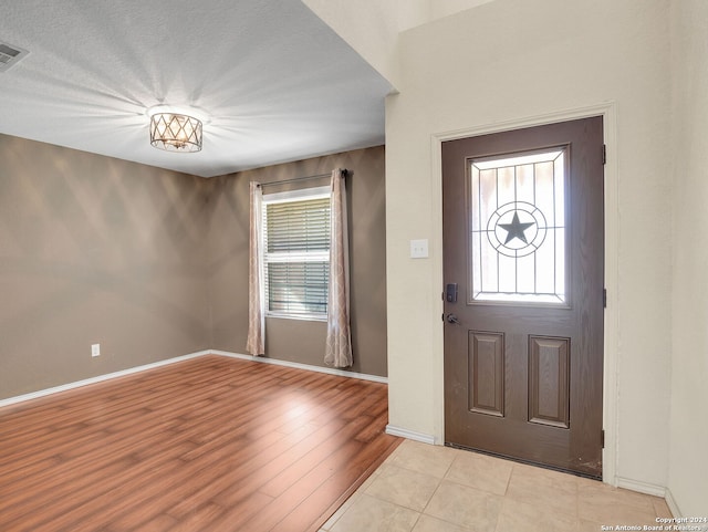 entryway featuring light hardwood / wood-style floors and a textured ceiling