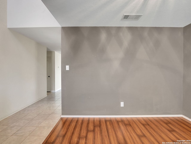 empty room with light hardwood / wood-style flooring and a textured ceiling