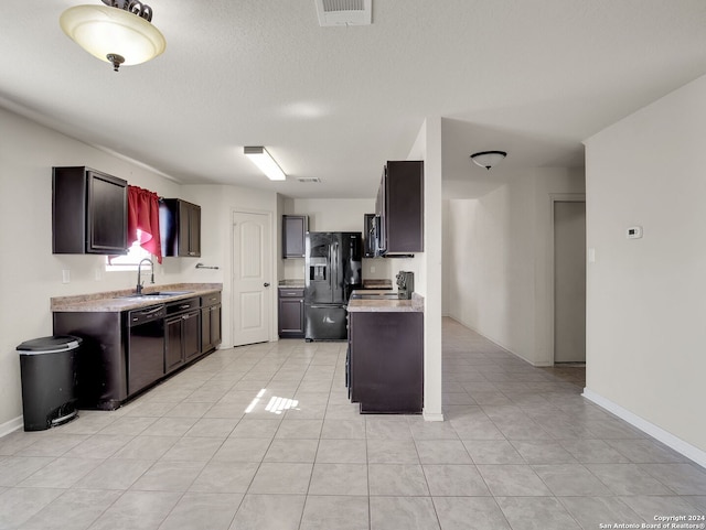 kitchen featuring black appliances, light tile patterned flooring, and sink