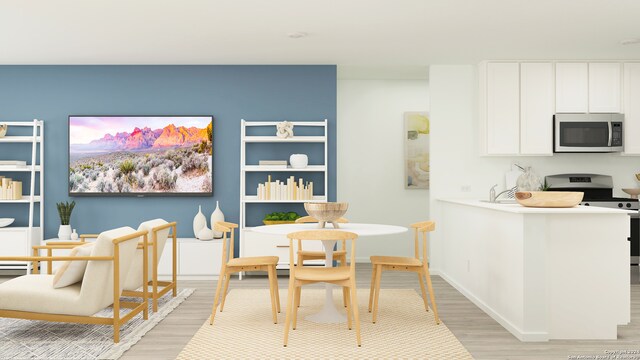 interior space with electric range, white cabinets, and light wood-type flooring