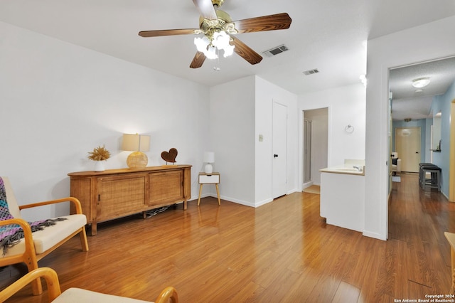 living area with ceiling fan and wood-type flooring