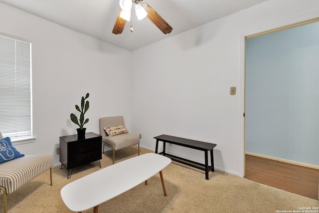 living area with ceiling fan and light hardwood / wood-style flooring