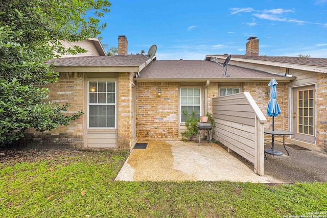 rear view of house with a yard and a patio