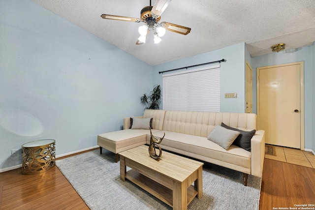 living room with ceiling fan, wood-type flooring, and a textured ceiling