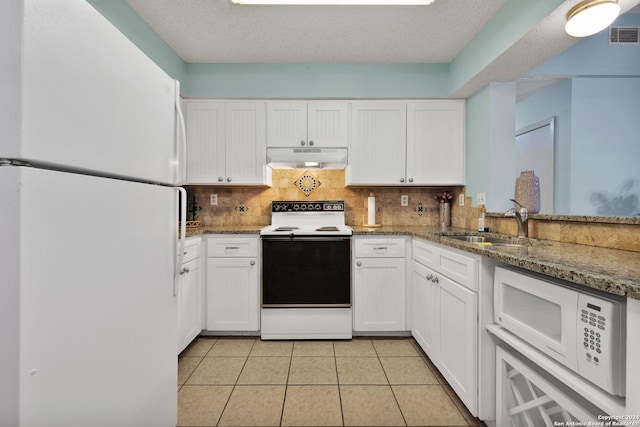 kitchen with white cabinetry, backsplash, dark stone countertops, white appliances, and light tile patterned floors