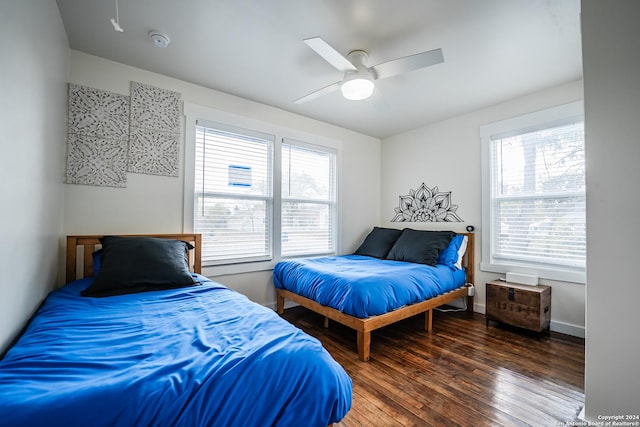 bedroom with dark hardwood / wood-style flooring and ceiling fan