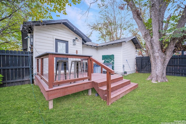 rear view of house featuring a yard and a wooden deck