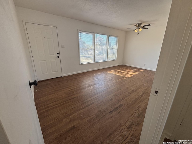 interior space with a textured ceiling, dark hardwood / wood-style floors, and ceiling fan