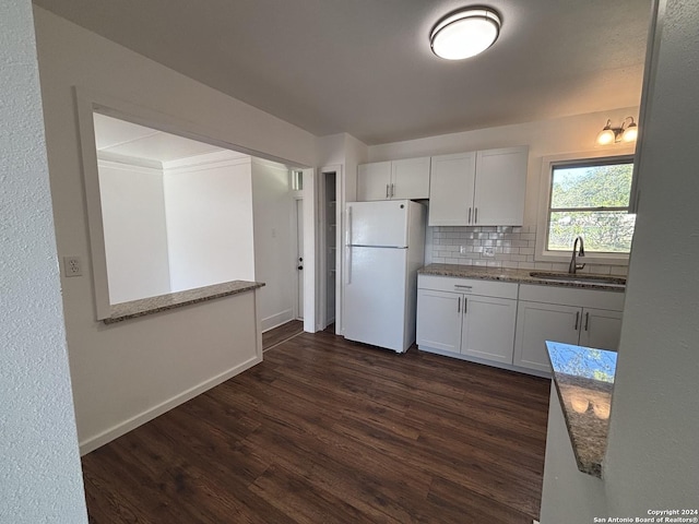 kitchen with white fridge, white cabinetry, sink, and dark wood-type flooring