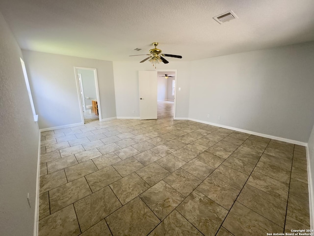 empty room with a textured ceiling and ceiling fan