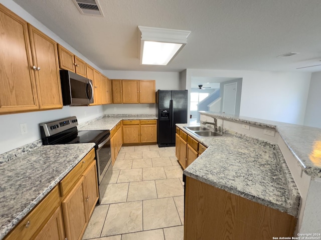 kitchen featuring ceiling fan, sink, stainless steel appliances, light stone counters, and light tile patterned flooring