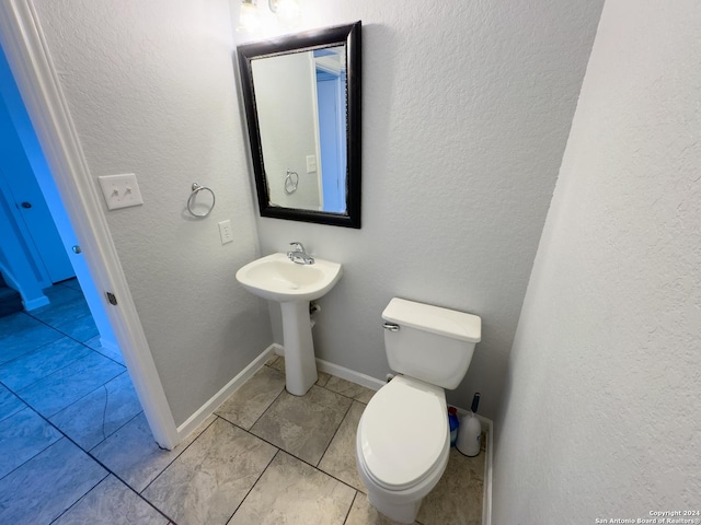 bathroom with tile patterned flooring, toilet, and sink