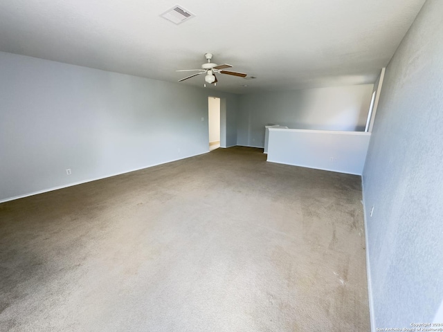 empty room with ceiling fan and dark carpet