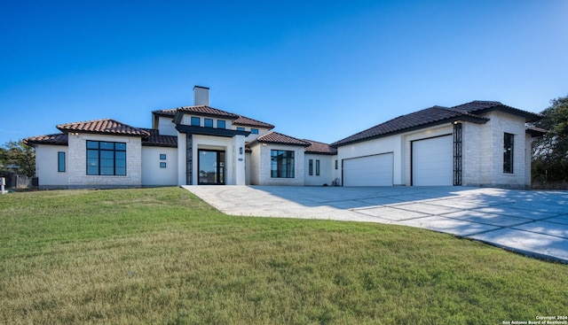 mediterranean / spanish home with a garage and a front lawn