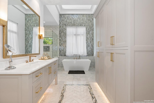 bathroom featuring a bathtub, vanity, a skylight, and plenty of natural light