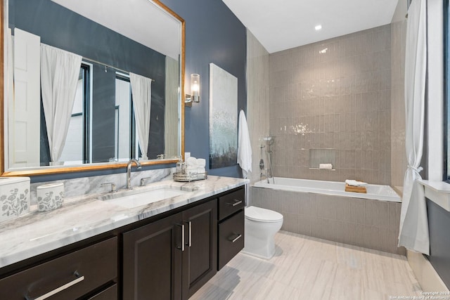 full bathroom featuring vanity, toilet, and tiled shower / bath combo