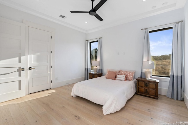 bedroom featuring ceiling fan, light hardwood / wood-style floors, and crown molding