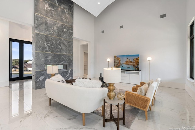 living room with a fireplace and high vaulted ceiling