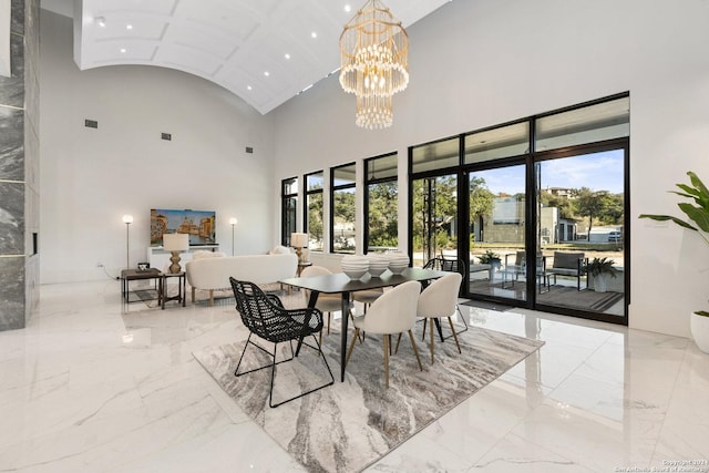 dining space featuring high vaulted ceiling, plenty of natural light, and a notable chandelier