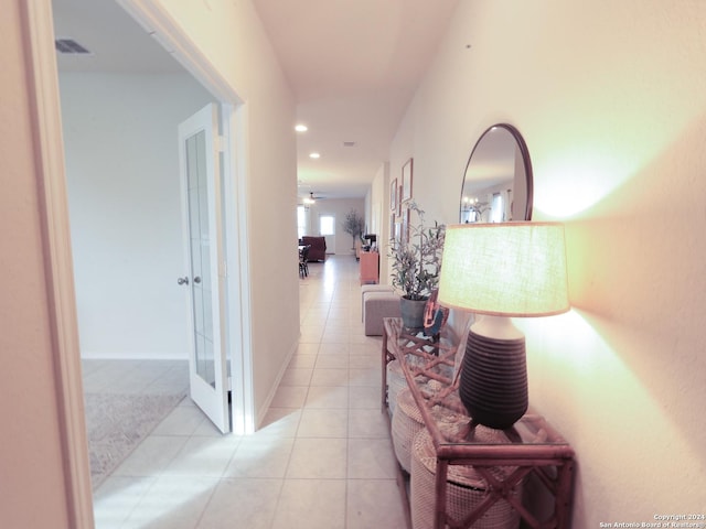 corridor featuring light tile patterned floors and a chandelier