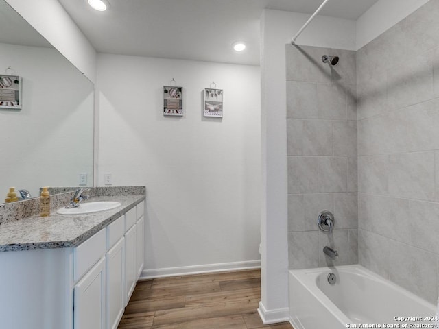 bathroom with vanity, tiled shower / bath, and hardwood / wood-style flooring