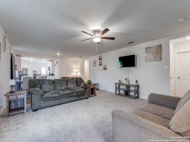 living room with ceiling fan and light colored carpet