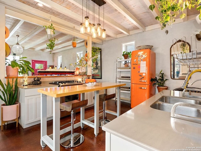 kitchen with pendant lighting, sink, beamed ceiling, white cabinetry, and wood ceiling