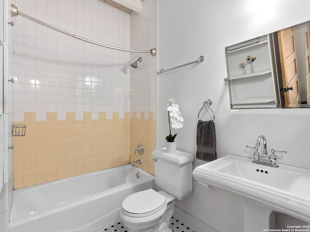 full bathroom featuring tile patterned flooring, toilet, tiled shower / bath, and sink