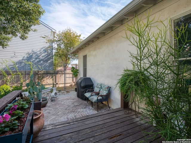 wooden terrace featuring a grill and a patio