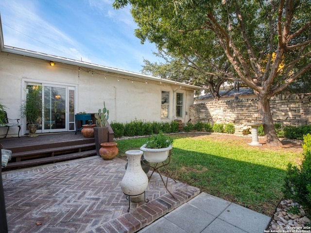 rear view of house with a patio area, a yard, and a deck