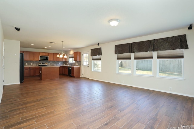 unfurnished living room featuring dark hardwood / wood-style floors and an inviting chandelier