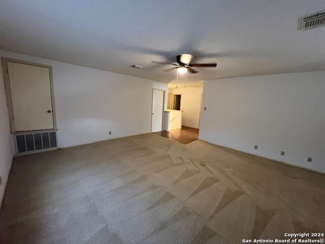 empty room with ceiling fan and light colored carpet