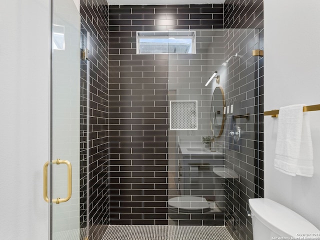 bathroom with toilet and a shower with shower door