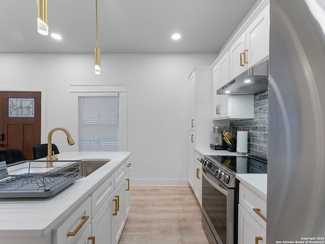 kitchen with appliances with stainless steel finishes, decorative light fixtures, white cabinetry, and sink