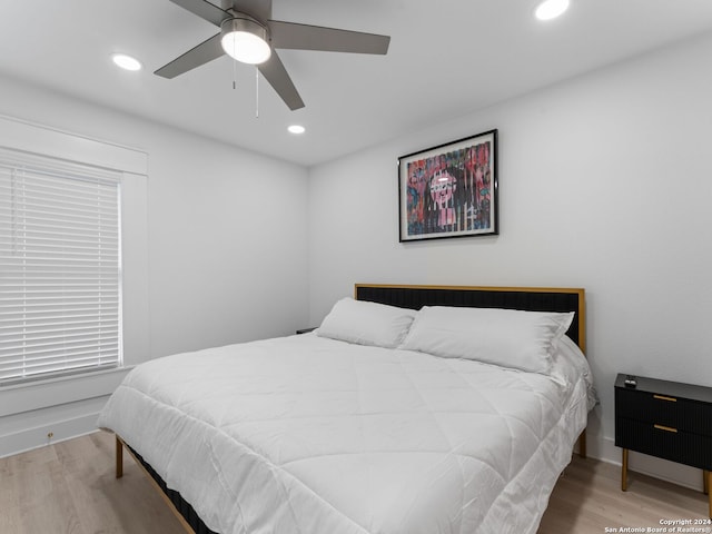 bedroom with ceiling fan and light hardwood / wood-style flooring