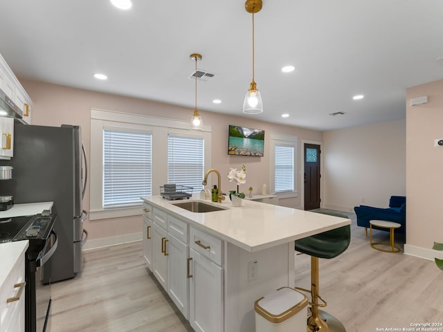 kitchen featuring white cabinetry, sink, black electric range oven, an island with sink, and light wood-type flooring