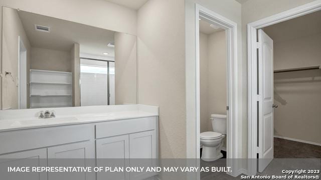 bathroom with vanity, an enclosed shower, and toilet