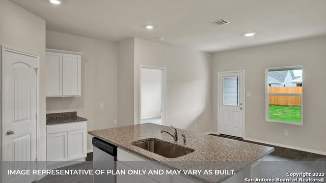 kitchen featuring white cabinetry, sink, stainless steel dishwasher, and stone countertops