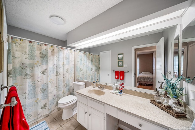 bathroom featuring tile patterned flooring, vanity, toilet, and a textured ceiling