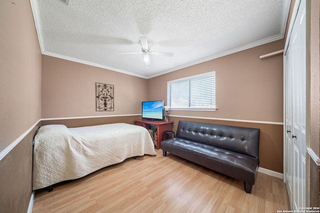 bedroom with ornamental molding, a textured ceiling, ceiling fan, hardwood / wood-style floors, and a closet