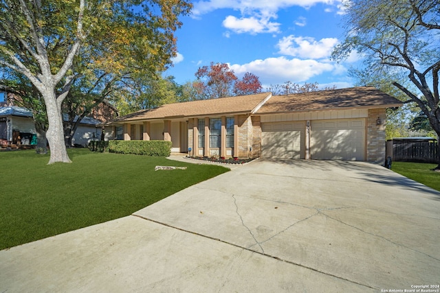 ranch-style house featuring a front yard and a garage