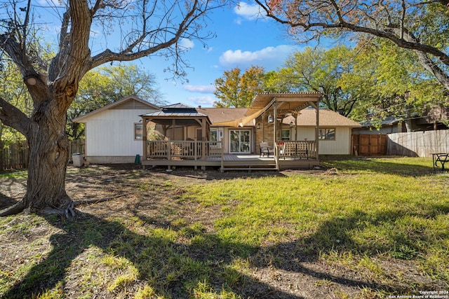 rear view of house with a gazebo, a wooden deck, and a lawn