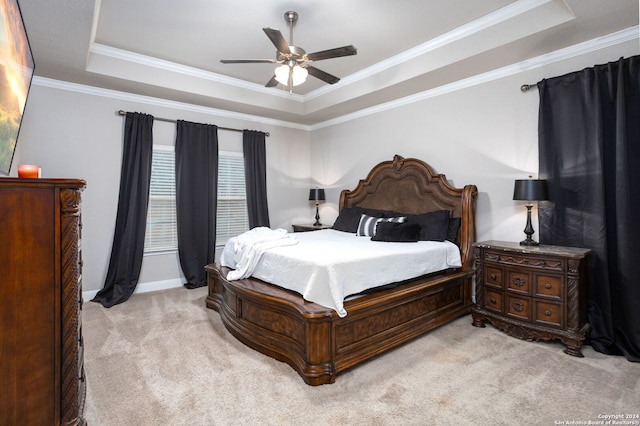 carpeted bedroom with a raised ceiling, ceiling fan, and ornamental molding