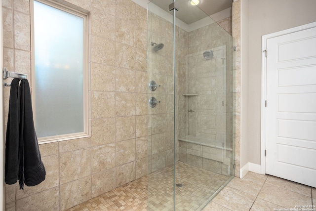 bathroom with tiled shower and tile patterned floors