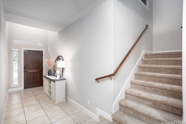 entrance foyer featuring light tile patterned floors and a textured ceiling